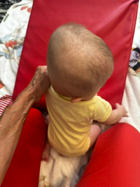 Assessing an infant's head shape and symmetry during an evaluation.