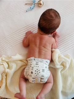 A baby being guided through head and neck movement during a torticollis session.