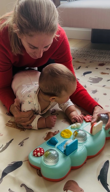 A baby propped on their forearms during supervised tummy time.