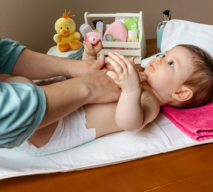 A therapist gently working with an alert baby during a wakeful play session.